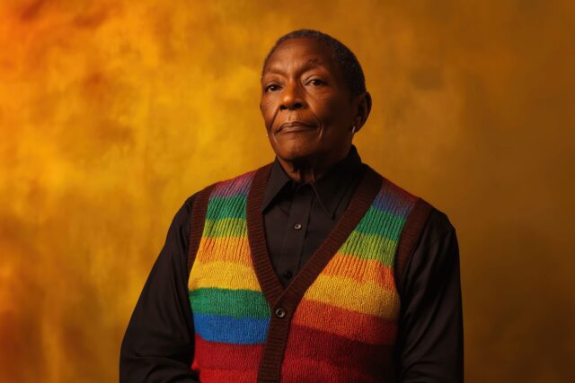 A person in a rainbow vest