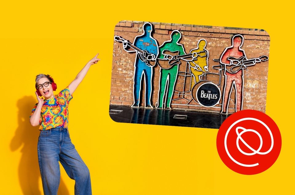 Person in colorful shirt pointing at Beatles mural with vibrant background.